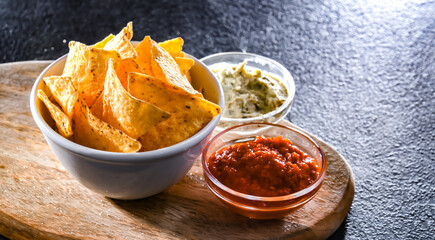 Composition with a bowl of tortilla chips and dipping sauces
