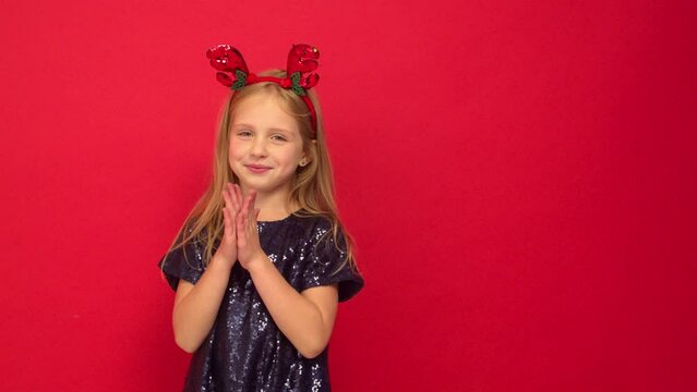 Smiling funny child (kid, girl) in Reindeer Hairband. 