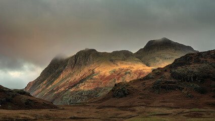 Stunning landscape of dramatic sunrise light over Blea Tarn in Lake District with stunning light