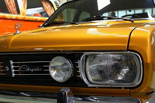 Front mask and headlights of large saloon car Chrysler 180 producet in Europe in years 1970-1982. Golden metallic colour, displayed on car expo in Nitra, Slovakia. 