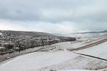 Fototapeta premium Enchanting aerial scenic view of the Mosel valley and the town of Bernkastel-kues Germany covered in snow during winter 