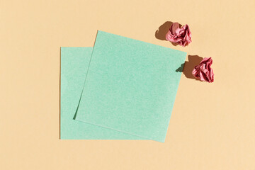 Blue greeting cards on beige background. Hard light, top view.