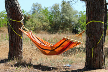 girl with unrecognizable covered face sleeping in the hammock hanging between two trees
