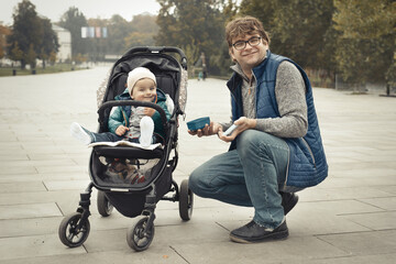 Couple of father and son in baby carriage in autumn park