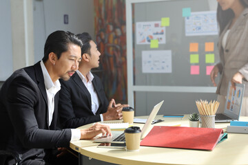 Young business people meeting together with team and using laptop computer for present graph report