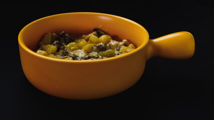 Yellow ceramic plate in the shape of a frying pan filled with potatoes with meat and cheese. Foodie