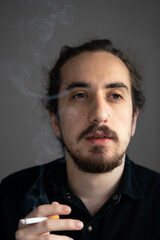 sad man smoking cigarette at home