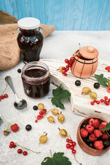 assortment of jam, seasonal berries of black, red currant, gooseberry and raspberry