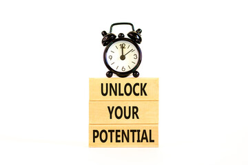 Unlock your potential symbol. Concept words Unlock your potential on wooden blocks. Black alarm clock. Beautiful white background. Business, psychological unlock your potential concept. Copy space.