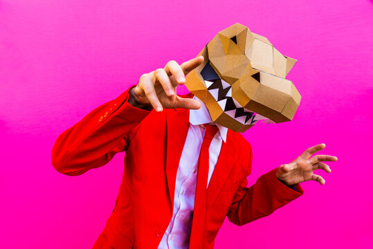 Cool man wearing  funny 3d origami mask and costume on colorful background