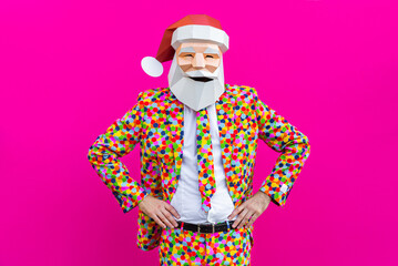 Man with funny Santa Claus low poly origami mask on colored background, colorful costume  for...