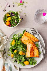 Delicious lunch with salad and fried char, healthy red fish and microgreens with cherry tomatoes, top view, copy space