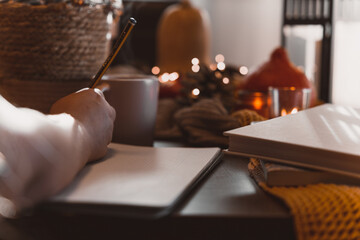 autumn photo on table with candles writing in a notebook