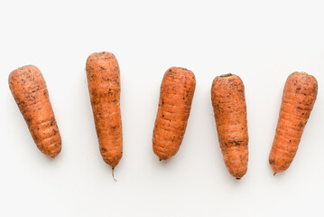 Carrots on a white background. Dirty carrot.