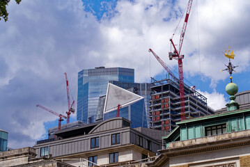 Cityscape with skyscrapers and cranes at City of London on a blue cloudy summer day. Photo taken August 1st, 2022, London, United Kingdom.