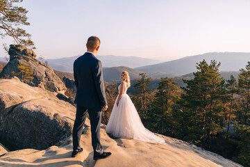 beautiful young bride and groom standing among the rocks.