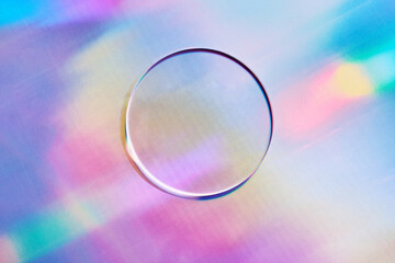 Empty round petri dish or glass slide on holographic background. Mockup for cosmetic or scientific product sample