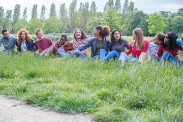 Group of young people from different ethnicities and cultures having a fun time together outdoors