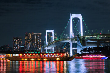 東京都 お台場海浜公園から見えるレインボーブリッジと屋形船の浮かぶ東京湾の夜景