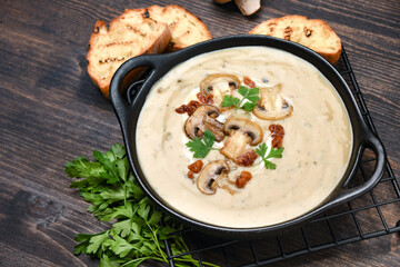 Mushroom soup with bread and fresh mushrooms on a wooden background