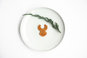 Smiling christmas cookie reindeer isolated on white plate background