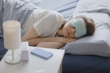 woman in bed with a sleep mask wakes up and turns off the alarm. a clock with a timer, a woman...