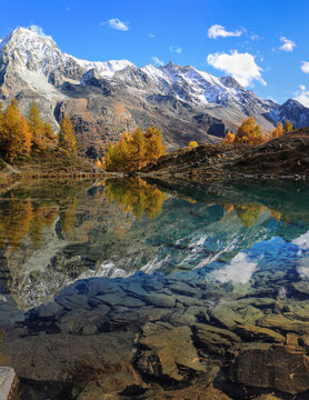 Lac Bleu of Arolla lake in Canton Valais in colorful autumn season with reflection of Dent de Veisivi and Dent di Perroc peaks.