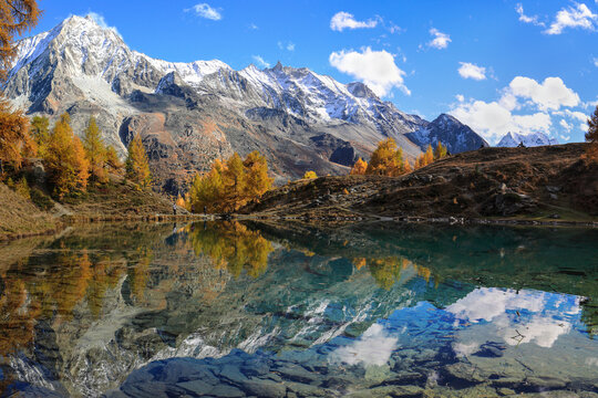 Lac Bleu of Arolla lake in Canton Valais in colorful autumn season with reflection of Dent de Veisivi and Dent di Perroc peaks.