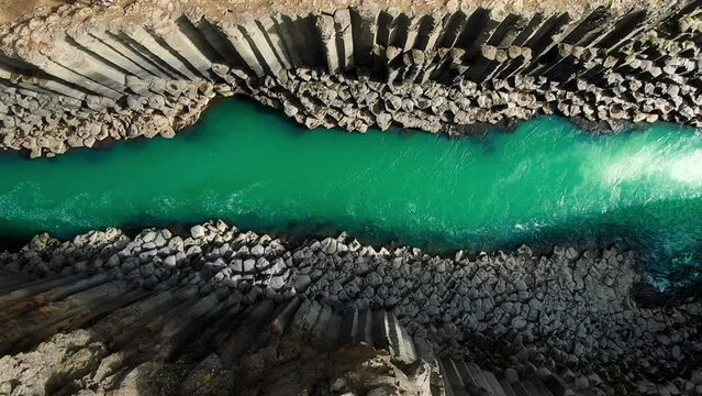 top down view aerial shot drone of scenic icelandic canyon studlagil,river flows into basaltic rock formation,iceland nature