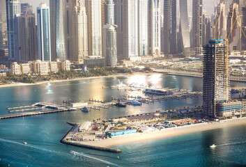Obraz premium Dubai Marina skyscrapers complex of residential and office buildings at sunset. Yachts and speed boats in the gulf water. Dubai, UAE