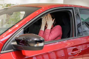 happy woman buys a red car at a car dealership. signing a trade-in contract and handing over keys, shaking hands. A successful woman chooses a new car. Rent a vehicle or repair service center.