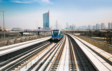 Dubai, UAE. Train, tube track with approaching train and  City view at the distance