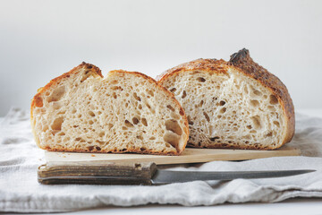 Round fresh bread lies on the cutting board. Baking and confectionery in a bakery or restaurant. homemade yeast-free sourdough bread. Healthy food