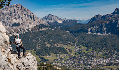 a Girl is doing via ferrata in dolomite's 