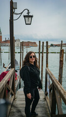 Obraz na płótnie Canvas Woman is standing on a small bridge in Venice