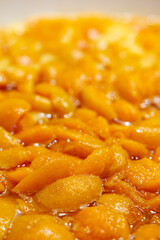Apricots are cooked in a pan. Apricot jam. Pieces of fruit. Home preservation.