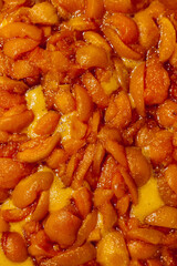 Apricots are cooked in a pan. Apricot jam. Pieces of fruit. Home preservation.