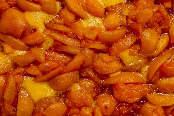 Apricots are cooked in a pan. Apricot jam. Pieces of fruit. Home preservation.