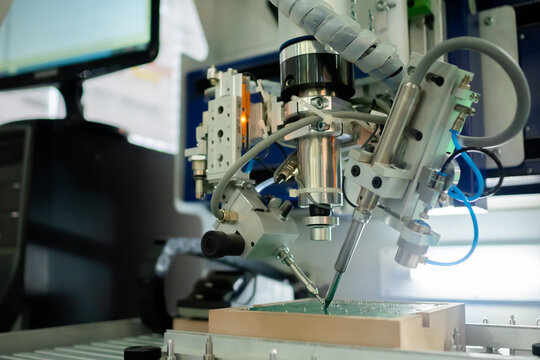 Soldering machine: process of selective soldering components to printed circuit boards at factory, exhibition. Technology, industrial, robotic, electronic, production, manufacturing concept