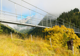 Obraz premium Holzgau suspension bridge in lech valley in autumn with indian summer