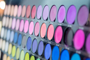 Colorful eyeshadow pallet for make up in cosmetic store - close up view, selective focus. Makeup, beauty, fashion, glamour concept