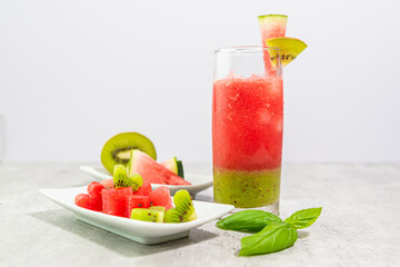 Primo piano di bicchiere cocktail con anguria e kiwi con caldi colori estivi