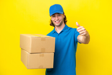 Delivery handsome man isolated on yellow background giving a thumbs up gesture