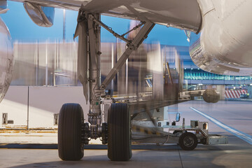 Loading of airplane at airport. Cargo container in blurred motion..