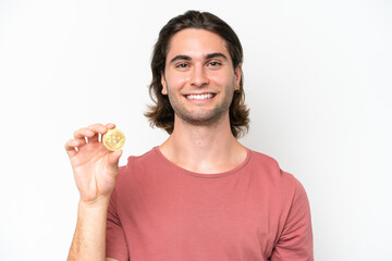 Young handsome man holding a Bitcoin isolated on white background smiling a lot