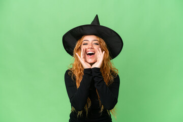 Young caucasian woman costume as witch isolated on green screen chroma key background shouting and announcing something
