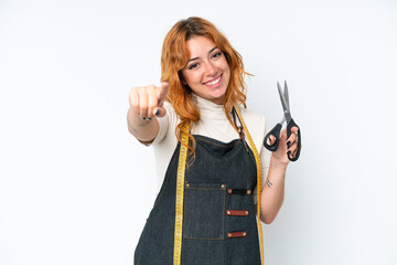 Young caucasian seamstress woman isolated on white background pointing front with happy expression