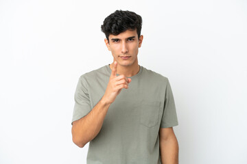 Young Argentinian man isolated on white background frustrated and pointing to the front