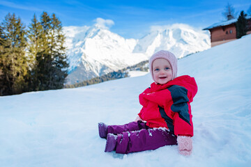 Fototapeta na wymiar Profile view of a happy girl sit in snow wear winter outfit