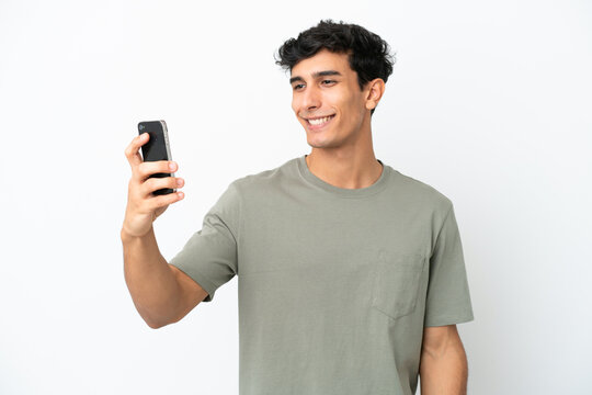 Young Argentinian man isolated on white background making a selfie
